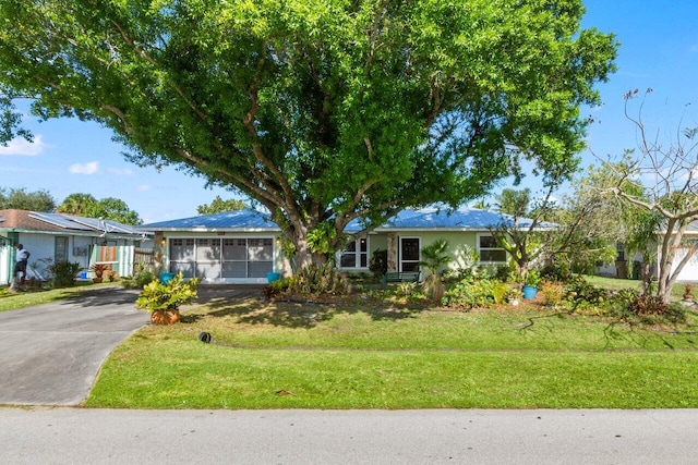 ranch-style house featuring a front lawn and aphalt driveway