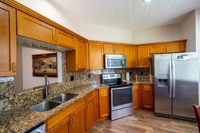 kitchen featuring brown cabinets, appliances with stainless steel finishes, and a sink
