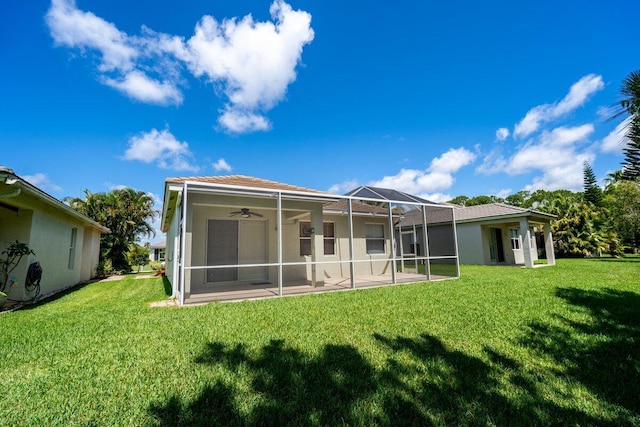 rear view of house featuring glass enclosure and a lawn