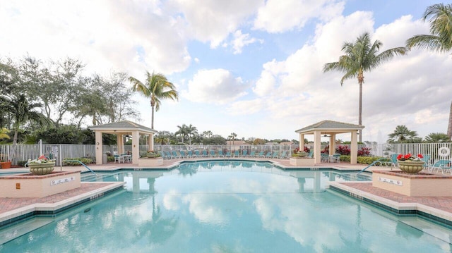 community pool with a gazebo, fence, and a patio