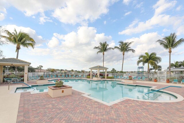 community pool with a gazebo, a patio area, and fence