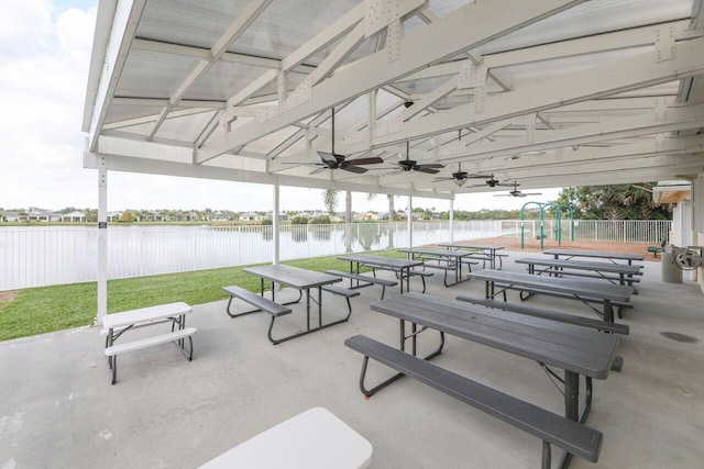 exterior space featuring a patio area, a water view, a lawn, and fence