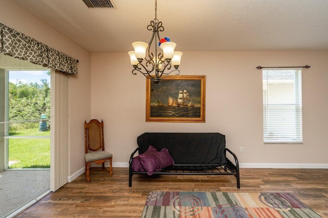 sitting room with visible vents, plenty of natural light, and wood finished floors