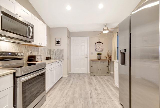 kitchen featuring white cabinets, ceiling fan, light wood-style flooring, stainless steel appliances, and backsplash