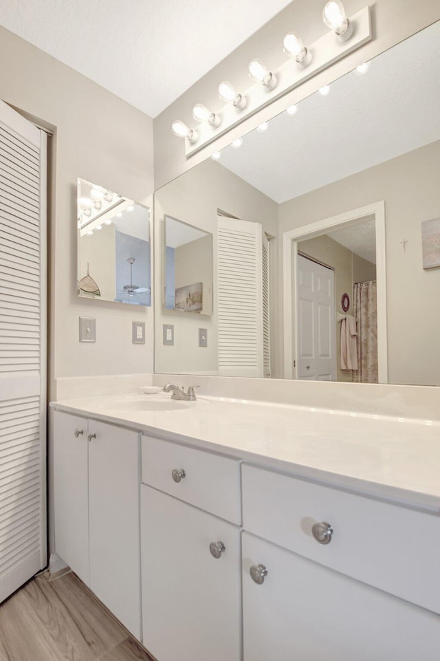 full bathroom featuring wood finished floors, a closet, and vanity