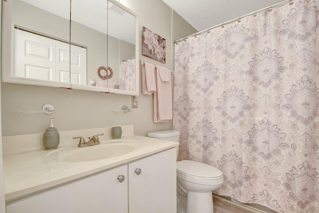 full bath with visible vents, vanity, toilet, and wood finished floors