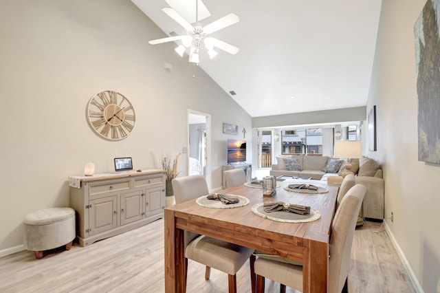 dining area featuring high vaulted ceiling, light wood-type flooring, baseboards, and a ceiling fan