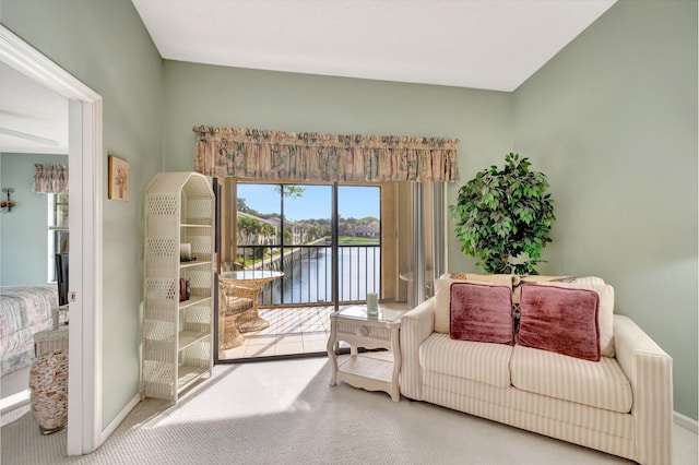 living room with carpet floors, a water view, and baseboards