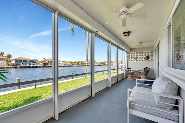 sunroom featuring a water view and ceiling fan