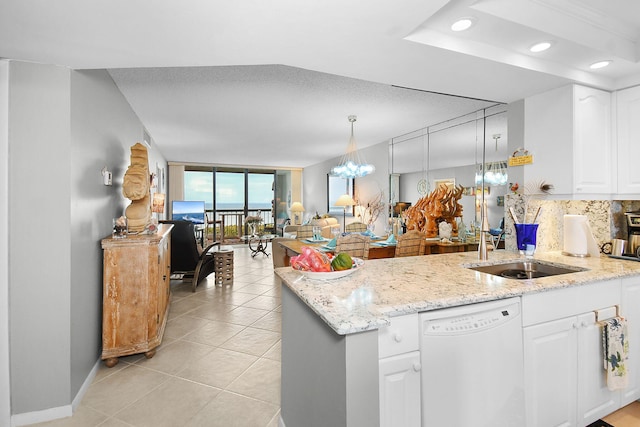 kitchen featuring expansive windows, light stone counters, dishwasher, pendant lighting, and white cabinets