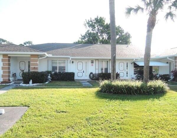 ranch-style house featuring a front lawn and stucco siding