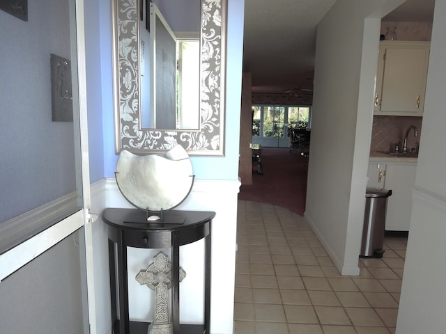 hallway featuring a sink and light tile patterned flooring