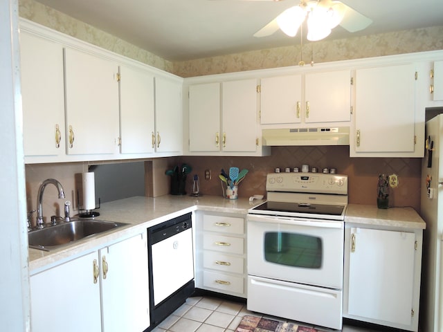 kitchen with white appliances, light countertops, under cabinet range hood, white cabinetry, and a sink