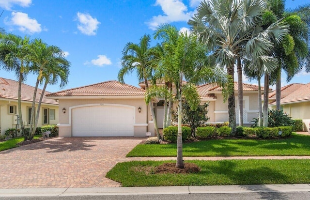 mediterranean / spanish house featuring a garage and a front lawn