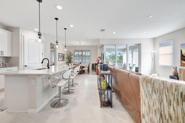 9633 Mosler Trl, Lake Worth, FL 33467 - kitchen featuring white cabinetry, recessed lighting, light countertops, open floor plan, and an island with sink