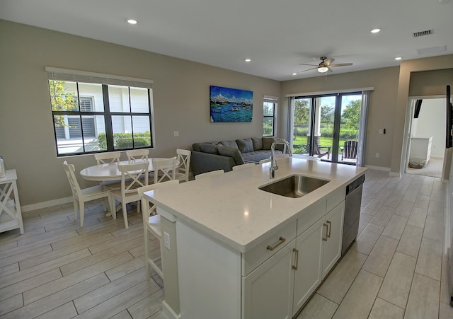 kitchen featuring recessed lighting, a sink, open floor plan, stainless steel dishwasher, and wood tiled floor