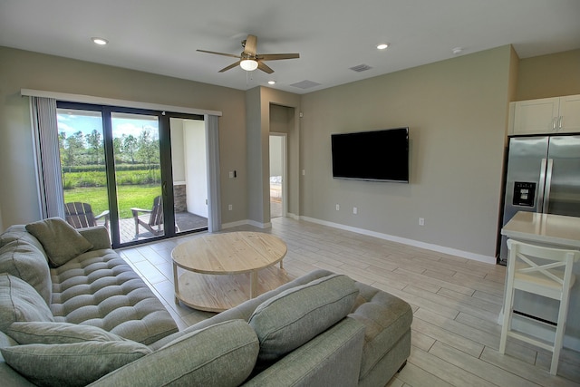 living area with baseboards, wood finish floors, visible vents, and recessed lighting