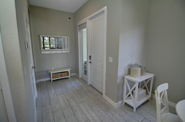 interior space featuring baseboards and wood tiled floor