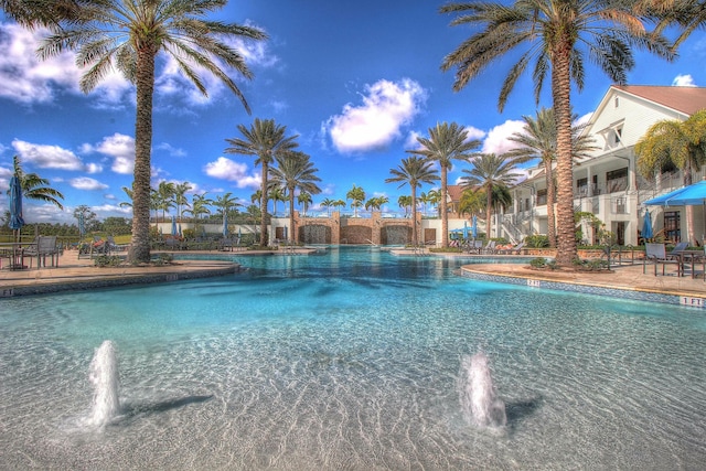 pool with a patio area and fence