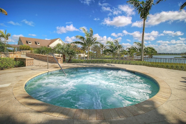 view of swimming pool with fence and a community hot tub