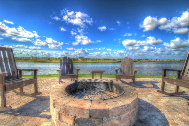 view of patio / terrace with an outdoor fire pit and a water view