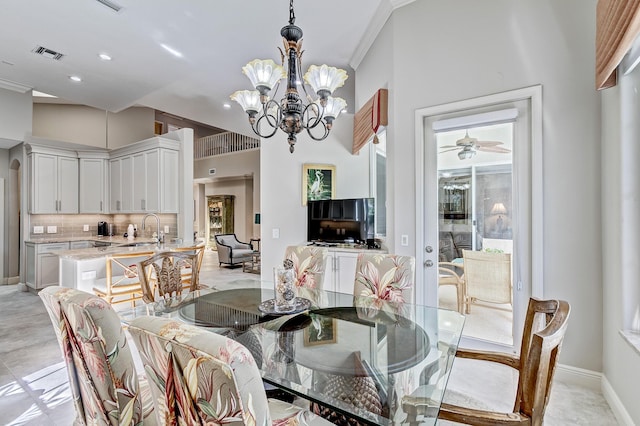 dining space with sink, a notable chandelier, and ornamental molding