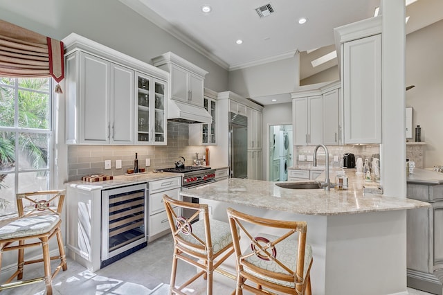 kitchen featuring a kitchen bar, beverage cooler, sink, and premium appliances