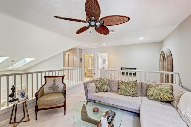 carpeted living room with a skylight and a textured ceiling