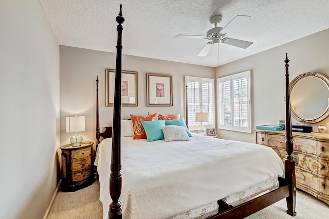 bedroom featuring ceiling fan, light colored carpet, and a textured ceiling