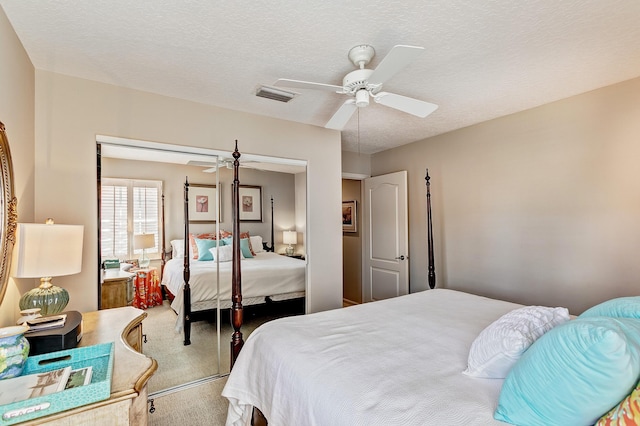 bedroom with ceiling fan, carpet floors, a textured ceiling, and a closet