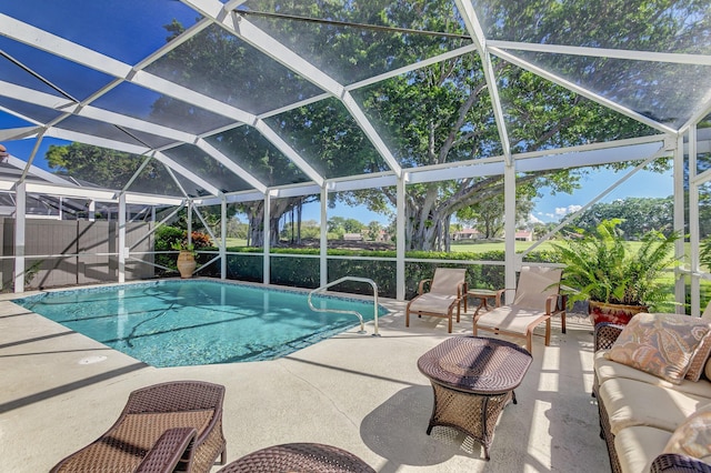 view of swimming pool featuring outdoor lounge area, glass enclosure, and a patio