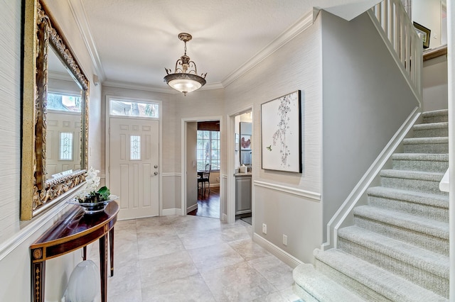 tiled foyer entrance featuring crown molding