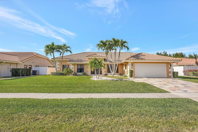 view of front of property featuring a garage, a front yard, and central air condition unit