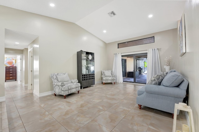 living area featuring vaulted ceiling and light tile patterned flooring