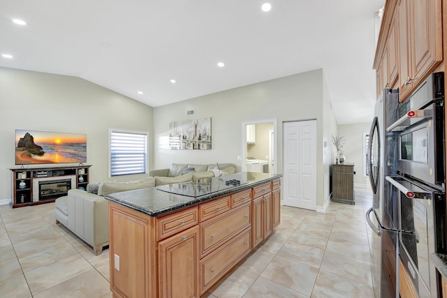 kitchen featuring a center island, vaulted ceiling, light tile patterned floors, dark stone countertops, and black electric stovetop