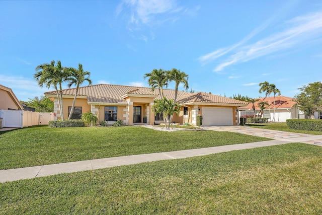 mediterranean / spanish home featuring a garage and a front yard