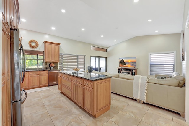 kitchen featuring vaulted ceiling, dark stone counters, a center island, light tile patterned floors, and stainless steel appliances