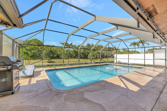 view of swimming pool featuring grilling area, a lanai, and a patio area