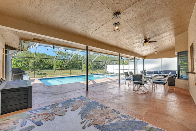 view of pool featuring ceiling fan, grilling area, a lanai, and a patio area