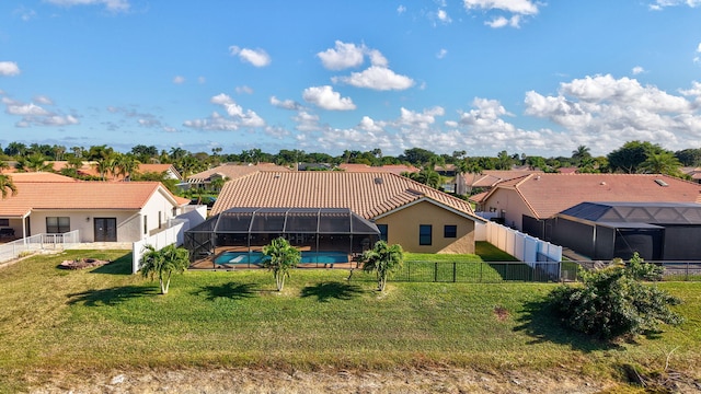 rear view of property with a fenced in pool, a yard, and glass enclosure