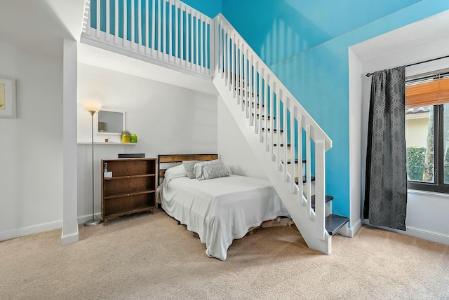 bedroom featuring light carpet and a towering ceiling