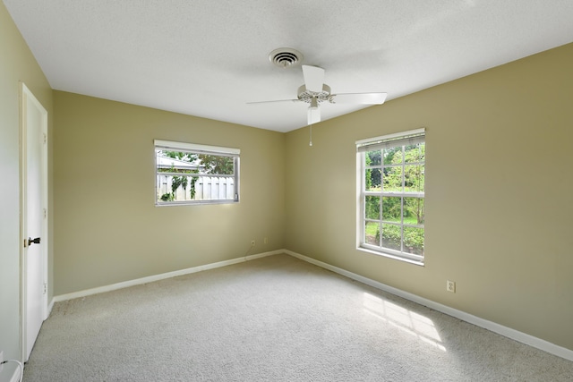 spare room with a wealth of natural light, visible vents, baseboards, and carpet floors