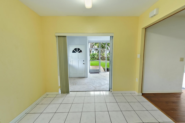 interior space with baseboards and light tile patterned flooring