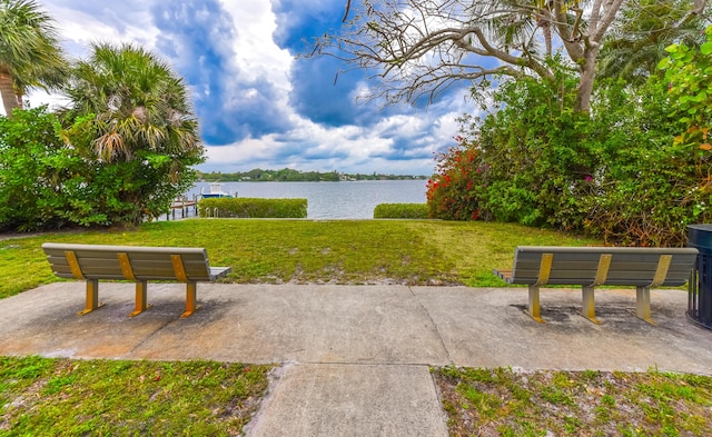 view of property's community with a yard and a water view