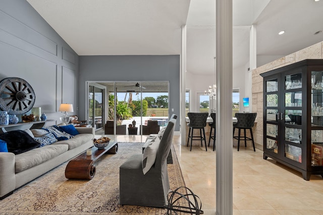 living room featuring an inviting chandelier, light tile patterned flooring, and high vaulted ceiling