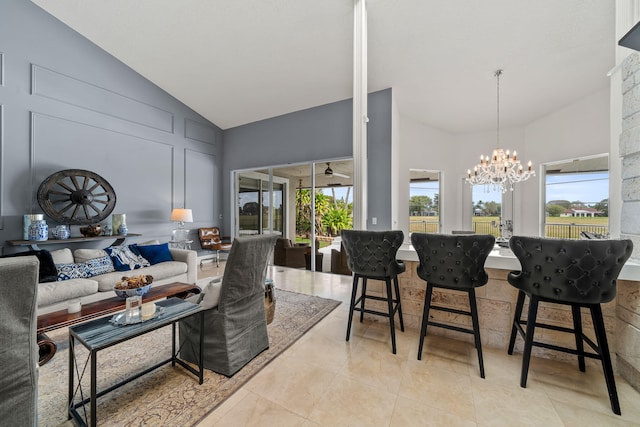 living room with a chandelier, high vaulted ceiling, and light tile patterned floors