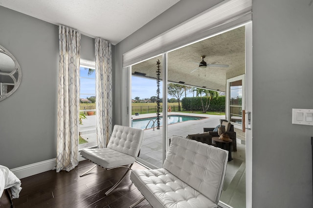 interior space featuring a fenced in pool and ceiling fan