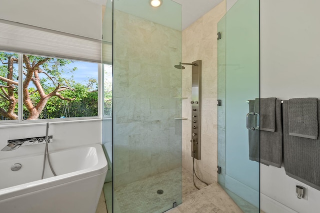 bathroom featuring a healthy amount of sunlight and separate shower and tub