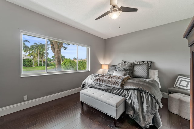 bedroom with ceiling fan, dark hardwood / wood-style flooring, and a textured ceiling