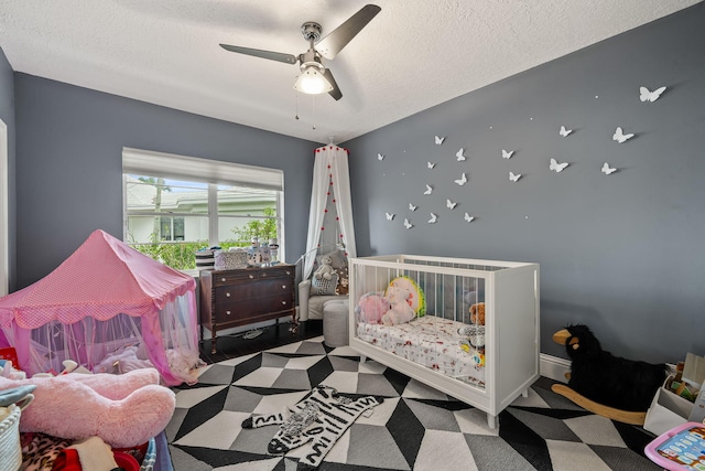 carpeted bedroom featuring ceiling fan and a textured ceiling